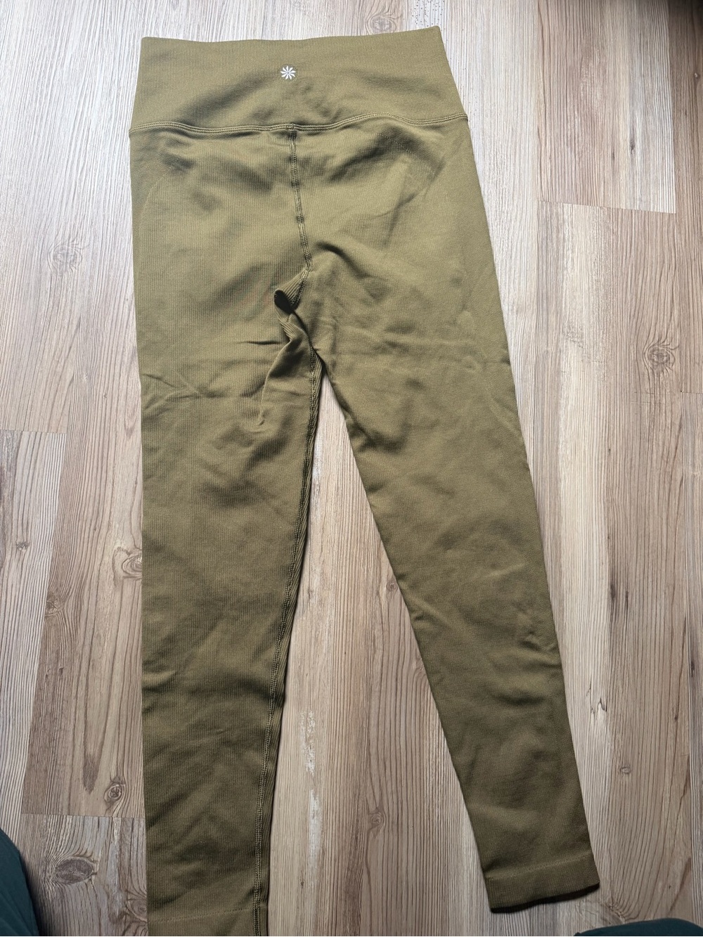 Athleta leggings feature a ribbed texture and a signature star-shaped logo on th